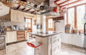 cocina con armarios blancos y taburete rojo en Beautiful Home In Ferrire-la-petite With Wifi en Ferrière-la-Petite