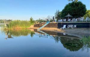 WęgorzynoCozy Apartment In Wegorzyno With Wifi的桌椅,享有水面的景色