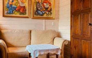 WęgorzynoCozy Apartment In Wegorzyno With Wifi的客厅里有一张沙发，墙上挂着画