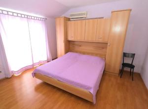 um quarto com uma cama, um armário e uma cadeira em Apartments Trogrlić em Hvar