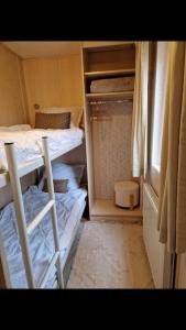 アーネムにある6 persoons chalet op de Veluweの二段ベッド2台、窓が備わる小さな客室です。