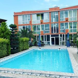 a swimming pool in front of a building at Hotel Buta in Batumi