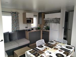 a kitchen and a living room with a table and chairs at CAMPING LE COTE D'OPALE in Cucq