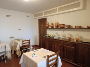 ein Restaurant mit 2 Tischen und einer Theke mit Küchenutensilien in der Unterkunft Bio Agriturismo Il Torrione in Saturnia