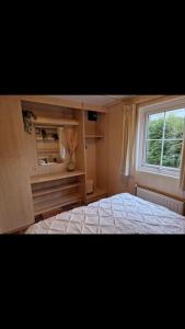 een slaapkamer met een bed en een raam bij 6 persoons chalet op de Veluwe in Arnhem