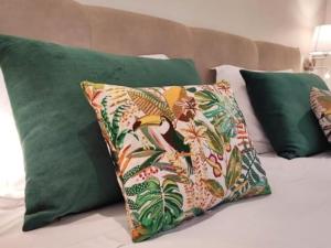 a bed with green pillows and a pillow with a bird on it at Albufeira Sol Villas III by Stay ici in Albufeira +39 photos