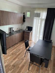 a kitchen with a black table and a kitchen with a table and chairs at Hotel Buta in Batumi