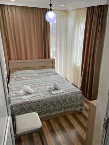 een slaapkamer met een bed, een stoel en een raam bij Hotel Buta in Batoemi