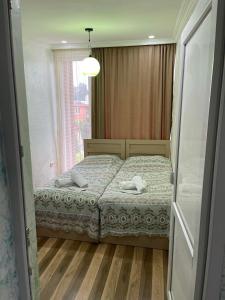 um quarto com uma cama e uma janela em Hotel Buta em Batumi