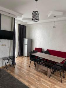 a living room with a table and a refrigerator at Hotel Buta in Batumi