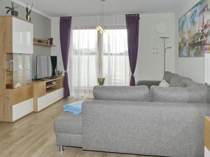 sala de estar con sofá y TV en Villa Sanddorn Wohnung 03, en Börgerende-Rethwisch