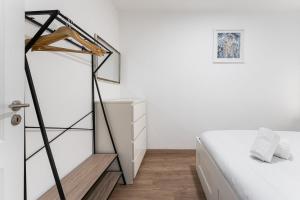 ヴィラ・ノヴァ・デ・ガイアにあるTrendy comfort in Vila Nova de Gaiaの白いベッドルーム(ベッド1台、ドレッサー付)