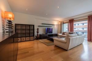 uma sala de estar com um sofá branco e uma mesa em 2 Bedroom Large apartment By Innkeeper em Lisboa
