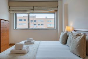 um quarto com uma cama grande e toalhas em 2 Bedroom Large apartment By Innkeeper em Lisboa