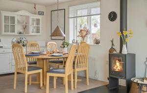 une cuisine avec une table et des chaises ainsi qu'une cheminée dans l'établissement 3 Bedroom Amazing Home In Fllenslev, à Føllenslev