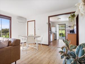 un soggiorno con un tavolo e un divano di Farm View Cottage a Margaret River Town