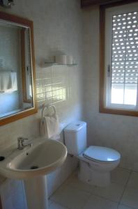 La salle de bains blanche est pourvue de toilettes et d'un lavabo. dans l'établissement HOSTAL Restaurante RANCHEIRO, à Vigo