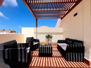 a patio with chairs and a table on a roof at Villa Olympia Lovely, Close to Town and Beaches with Private Pool & Fast WiFi in Corralejo