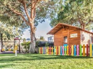 a wooden house with a colorful fence in a yard at Albufeira Sol Villas III by Stay ici in Albufeira