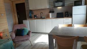 a kitchen with a pink chair and a kitchen table at Domus Mare Tiny House 1 in Wisełka