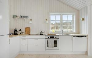 cocina con armarios blancos, fregadero y ventana en Beautiful Home In Aakirkeby With Kitchen en Vester Sømarken