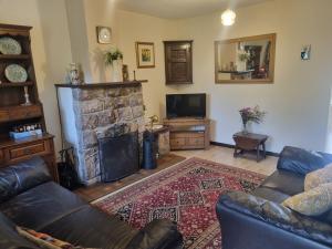 a living room with a couch and a fireplace at Sycamore Cottage in Conwy