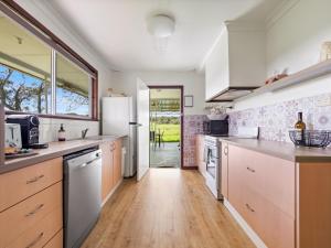 una cucina con elettrodomestici bianchi e pavimento in legno di Farm View Cottage a Margaret River Town Altre 15 foto