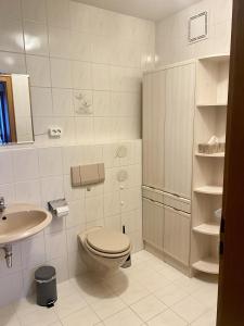 Baño blanco con aseo y lavamanos en Ferienwohnung starnberg en Starnberg