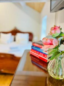 a stack of books on a table with a vase of flowers at The Ilkley Loft Suite in Ilkley