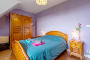 1 dormitorio con cama azul y cabecero de madera en Maison 100m de la plage, en Trégunc