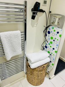 a bathroom with a basket with towels and a phone at The Ilkley Loft Suite in Ilkley
