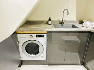 a kitchen with a washing machine and a sink at The Ilkley Loft Suite in Ilkley