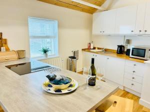 a kitchen with a table with a bowl and wine glasses at The Ilkley Loft Suite in Ilkley