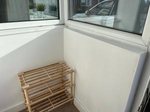 a small wooden bench sitting next to a window at Private flat close to Sunderland centre in Pallion