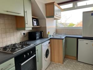 a kitchen with a stove top oven next to a sink at Private flat close to Sunderland centre in Pallion