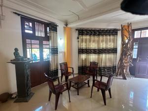 a dining room with a table and chairs and windows at Rafting Reach Layathraa in Nawalapitiya