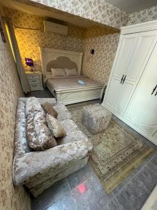 een woonkamer met een bank en een bed bij العين الهيلي مصباح ب 8 in Al Ain