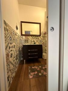a bathroom with a mirror and a dresser with a rug at Casa Patrizia in Giardini Naxos