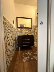 a bathroom with a mirror and a dresser with a rug at Casa Patrizia in Giardini Naxos +28 photos