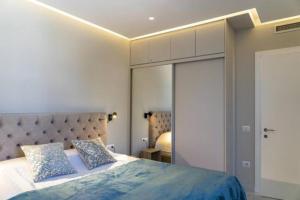 Beachfront Apartments- Horizon Residence في سارنده: غرفة نوم بسرير كبير ومرآة كبيرة