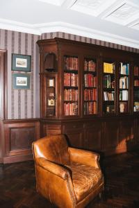 um sofá de couro num quarto com uma estante de livros em Les Tilleuls Etretat em Étretat
