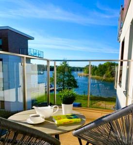 een tafel op een balkon met uitzicht op het water bij Marina Luna in Iława