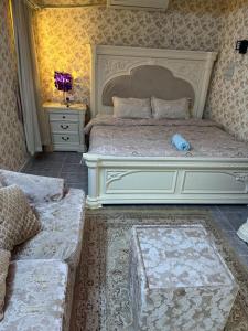 een slaapkamer met een groot wit bed en een bank bij العين الهيلي مصباح ب 8 in Al Ain