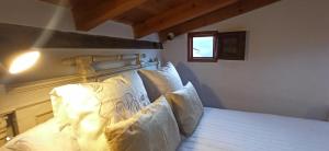 una camera da letto con letto, lenzuola e cuscini bianchi di 'La Casa de LoLa' casita de cuento con terraza ad Arenas de San Pedro