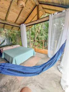 a bedroom with a hammock in a tent at Suíte de Vidro com Cachoeira no Quintal in Antônio Carlos
