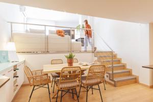 un comedor con mesa y sillas y una escalera en Bravissimo Hortes, 3-bedroom centre apartment, en Girona