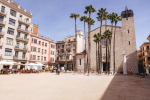una plaza de la ciudad con palmeras y edificios en Bravissimo Hortes, 3-bedroom centre apartment, en Girona
