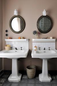 La salle de bains est pourvue de 2 lavabos blancs et de 2 miroirs. dans l'établissement Les Tilleuls Etretat, à Étretat