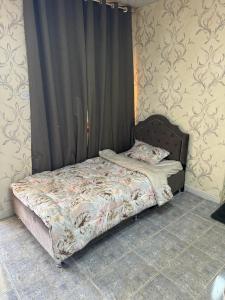 a bed sitting in a bedroom with a curtain at العين الهيلي مصباح ب 8 in Al Ain +7 photos