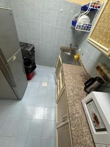 a small kitchen with a counter and a refrigerator at العين الهيلي مصباح ب 8 in Al Ain